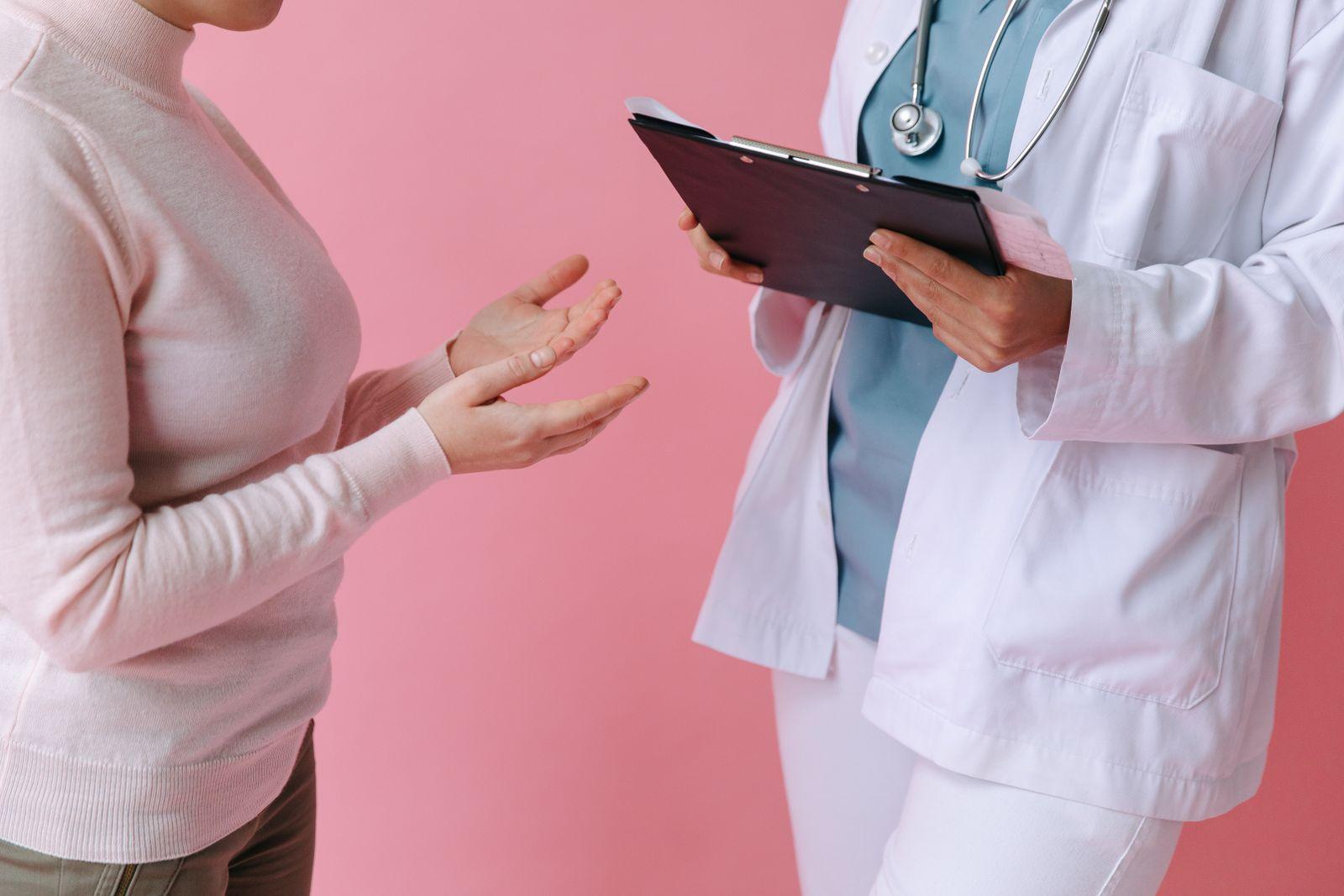 Patient consulting a doctor who is holding a clipboard